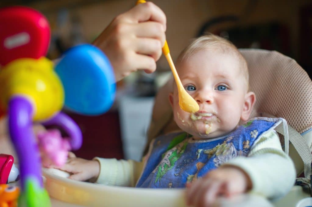 Mom feeds baby at home and gets dirty